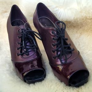 Vince Camuto patented leather peeptoe platform lace-up booties.